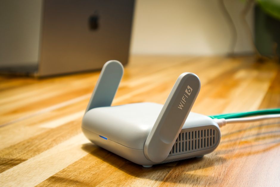 A sleek 5G home internet router placed on a window sill, with a blurred cityscape in the background.