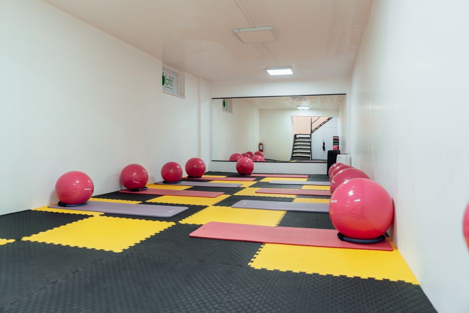An empty, serene airport yoga room with mats on the floor, ready for use by travelers seeking a quiet space to stretch or meditate.
