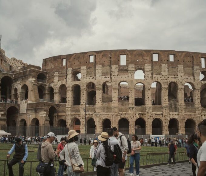 A wide shot of the ancient Roman Colosseum bustling with tourists, representing historical travel in Europe.