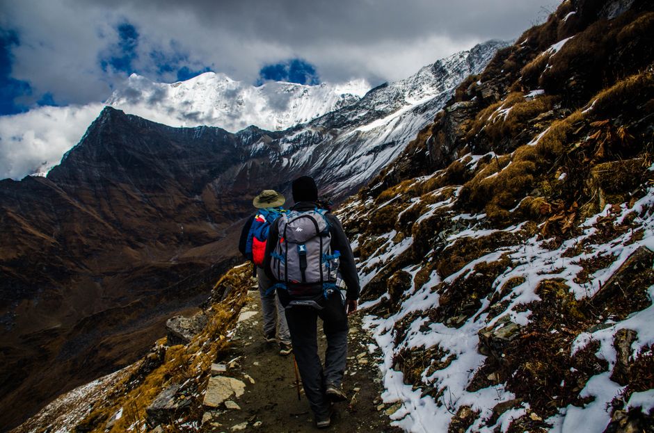 A group of backpackers hiking a trail through the dramatic, sprawling peaks of Patagonia, demonstrating safe adventure travel.