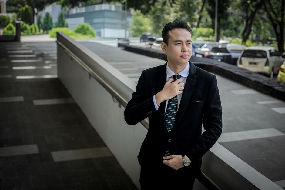 A man in a well-maintained, tailored suit stepping off a train, looking fresh and uncreased after a long journey.