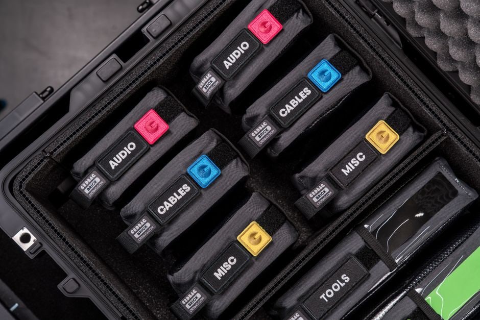 Close-up of a neatly organized travel tech pouch filled with various cables, power banks, and adapters.