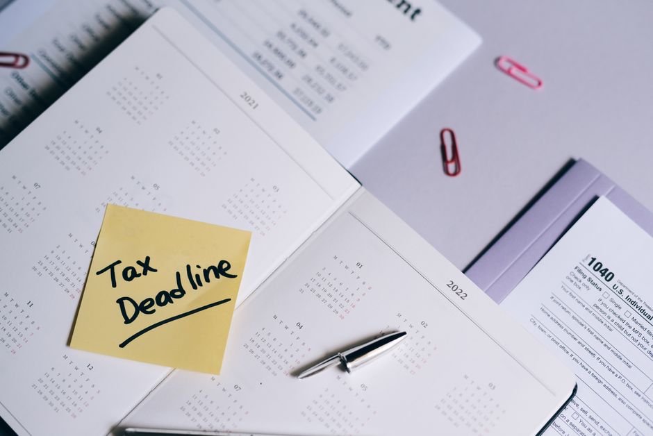 A close-up of a desk with a notebook, pen, and a calendar showing dates marked and sticky notes for a 90-day plan, indicating progress tracking.