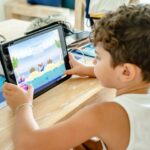A family, including a child and two parents, engaging with an educational game on a tablet, fostering interactive learning.