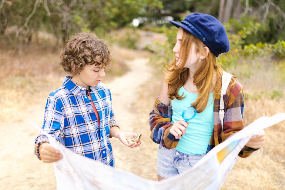 Two children and an adult pointing at a physical map spread open on a cafe table, planning their next move in a European city, emphasizing smart planning for a realistic seven-day city itinerary.