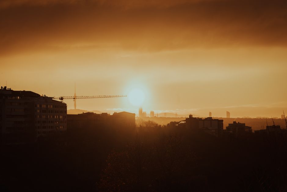 A serene city skyline at dawn with soft light, conveying the quiet potential of a city before it fully awakens, ideal for a weekend reset routine.