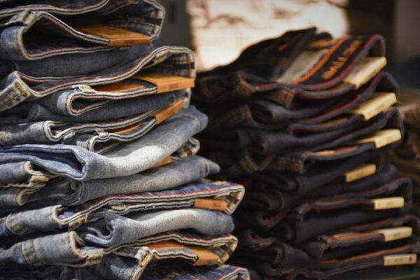 A large pile of discarded, low-quality fast fashion clothing items, symbolizing waste and poor value.