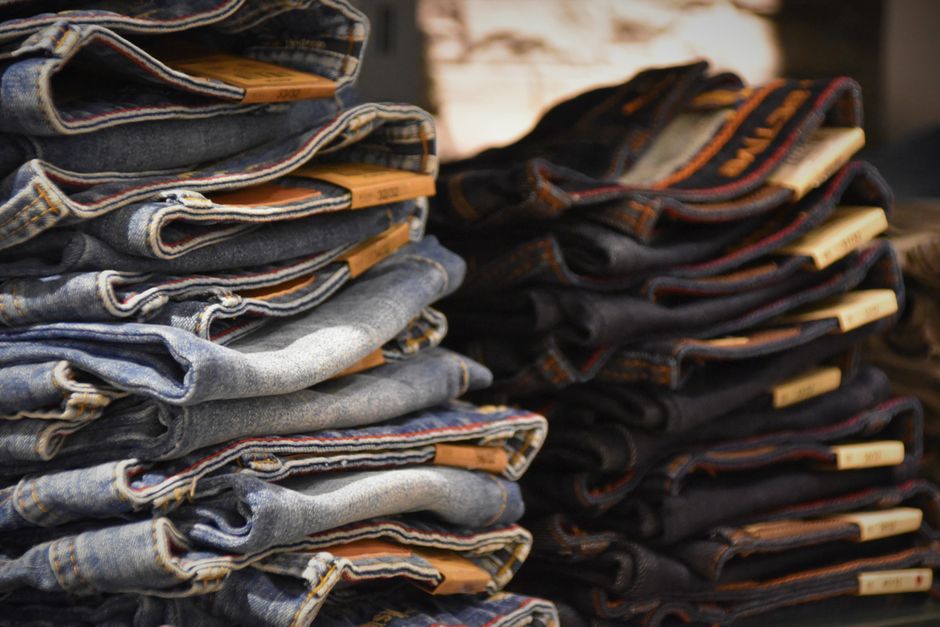 A large pile of discarded, low-quality fast fashion clothing items, symbolizing waste and poor value.