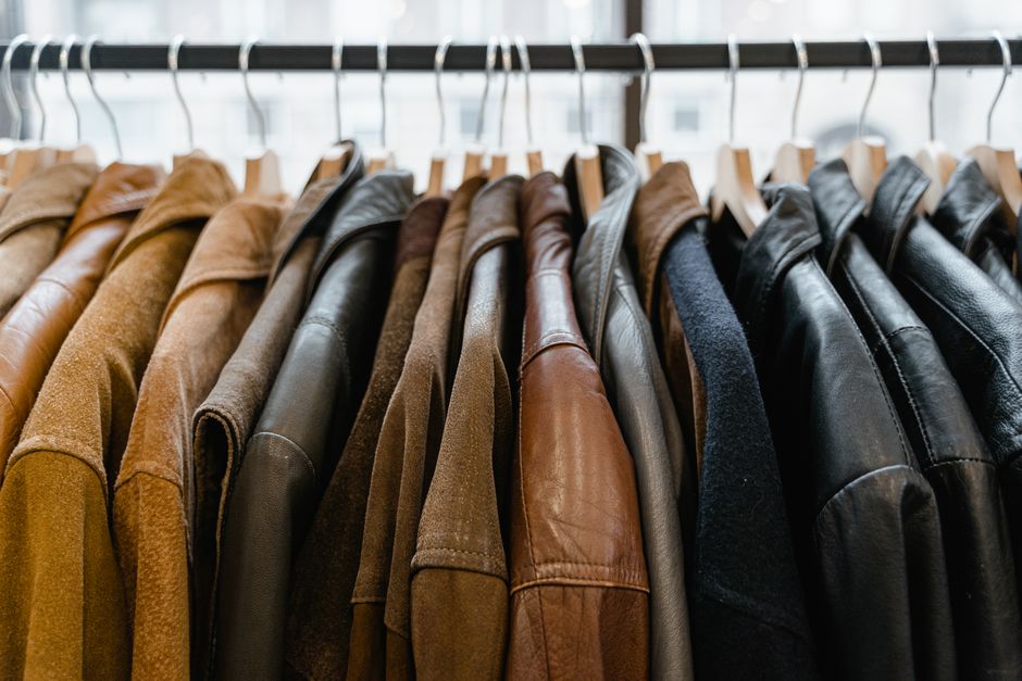 A neatly organized clothing rack displaying a collection of affordable workwear basics in neutral colors like blazers, trousers, and shirts, ready for mixing and matching.