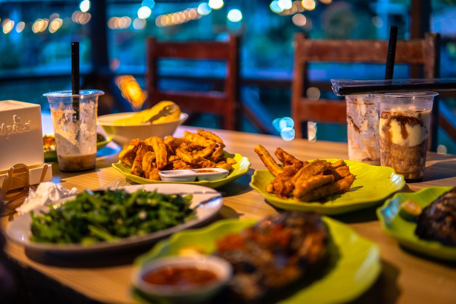 An aerial view of a table laden with an assortment of international street food, including tacos, empanadas, and skewers, showcasing the rich variety of culinary travel.