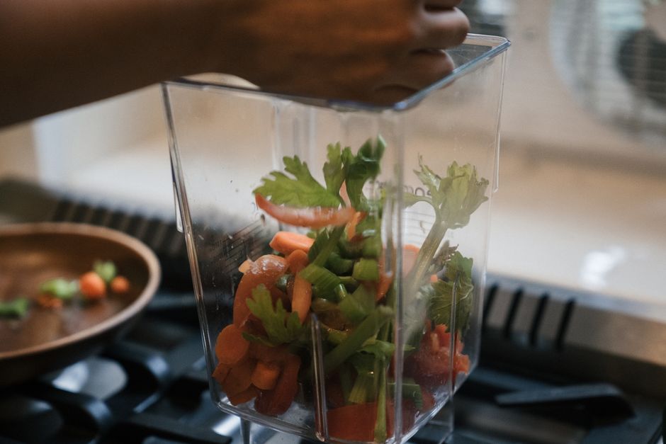 Various fresh, colorful vegetables like bell peppers, zucchini, and carrots, neatly chopped and stored in glass containers, ready for cooking.