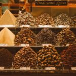 A vibrant, bustling spice stall at a market, with various colorful spices arranged in mounds, hinting at rich culinary traditions.