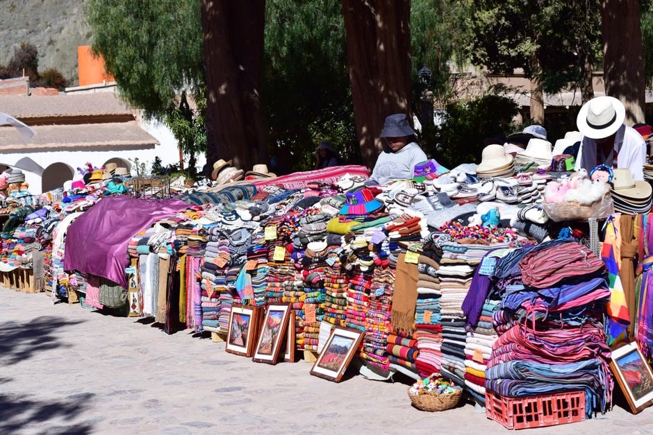 A vibrant, colorful street market in a South American city, with local crafts and fresh produce, reflecting cultural immersion.