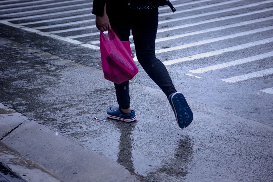 Close-up of stylish, waterproof commuter shoes on a wet cobblestone street, ready for rain and city walking.