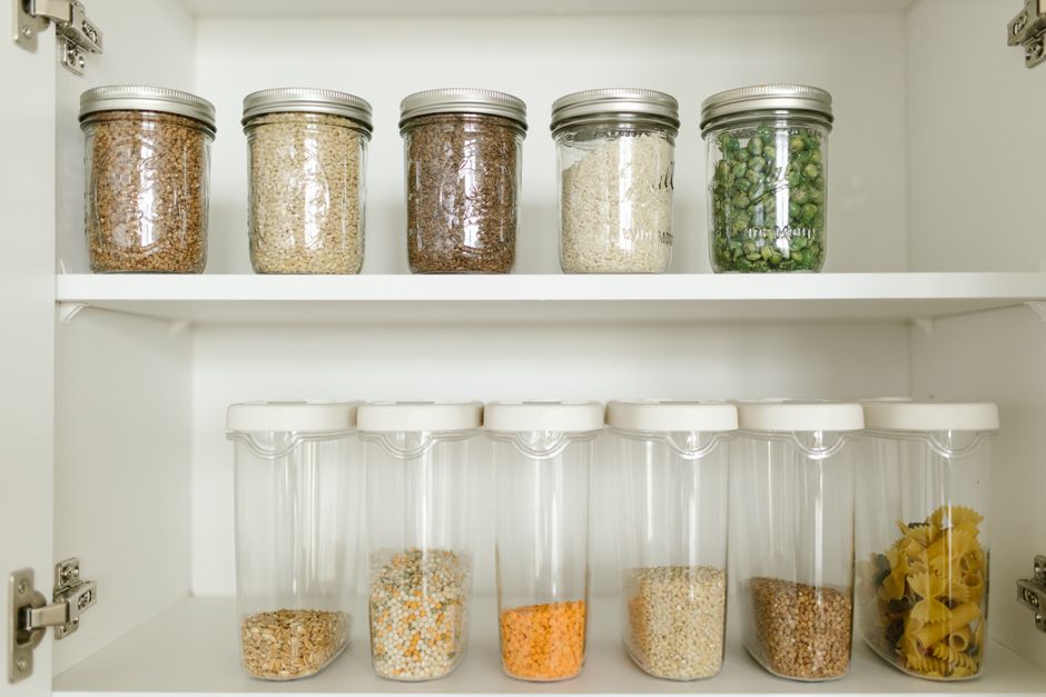 A compact but highly functional kitchen in a small apartment, showcasing wall-mounted storage, a magnetic knife strip, and stackable containers.