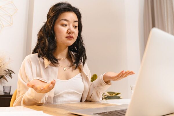 A person with a perplexed expression staring at a laptop screen displaying code, illustrating confusion from an AI hallucination.