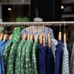 A bustling outdoor market stall in Copenhagen featuring various vintage clothing items, with people browsing.