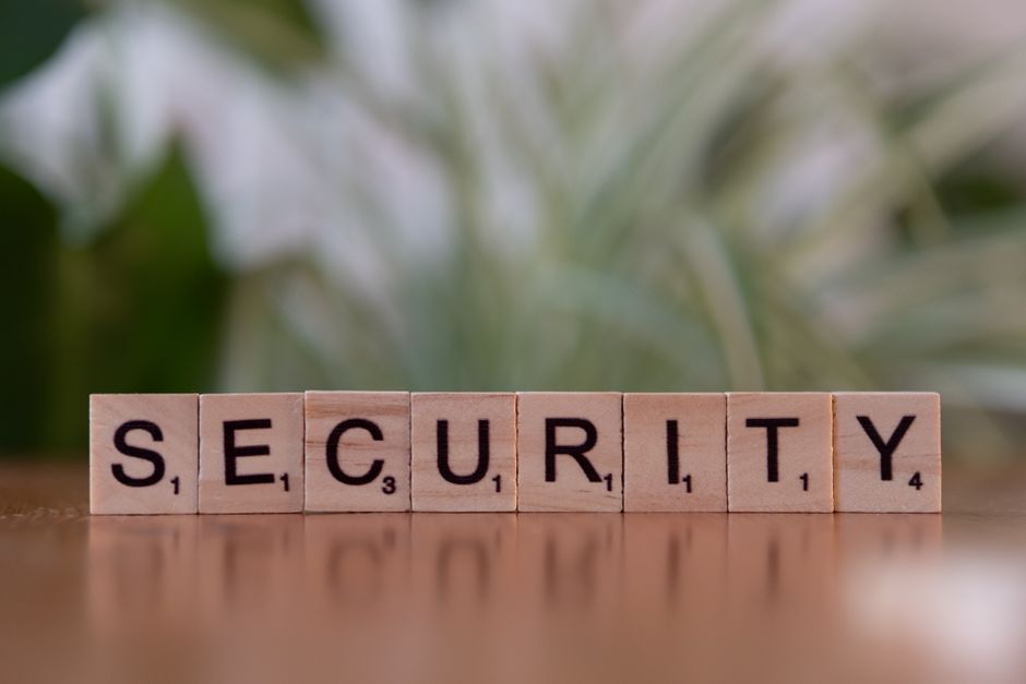 A stylized digital shield formed by glowing lines, with a padlock icon at its center, representing cybersecurity and data privacy.