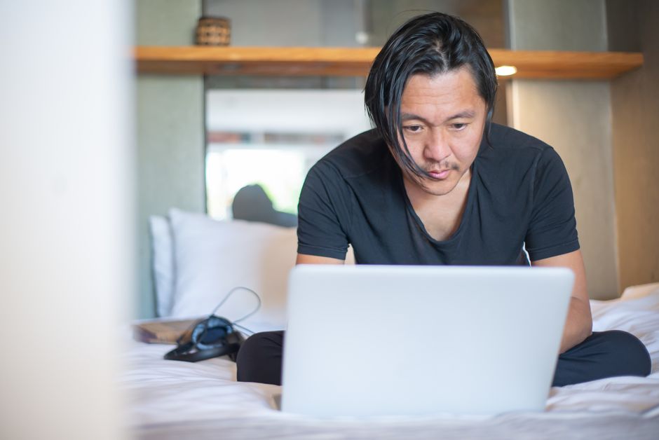 A remote worker in a modern, light-filled home office, surrounded by screens displaying AI-powered applications, illustrating global connectivity.