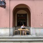 A person happily working on a laptop at a cafe with good internet, illustrating productive remote work trips.