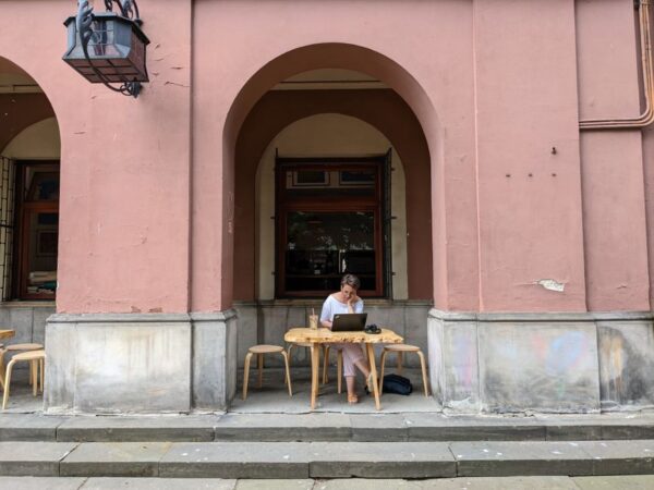 A person happily working on a laptop at a cafe with good internet, illustrating productive remote work trips.