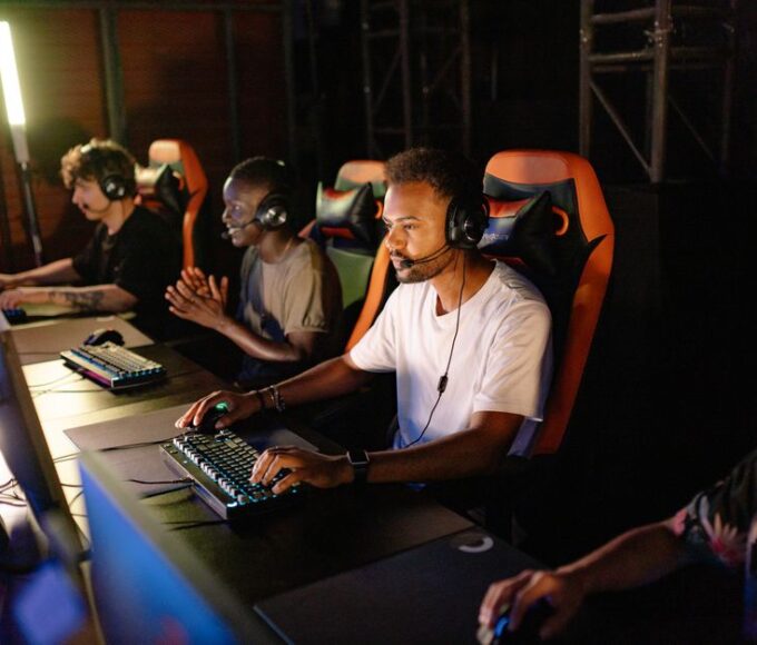 Four diverse gamers, two men and two women, smiling while on a private Discord call, each with a headset on, indicating social gaming without public chat.