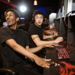 A group of diverse adult gamers wearing headsets, laughing and communicating while playing an online multiplayer game, illustrating how gaming communities can help adults make friends.