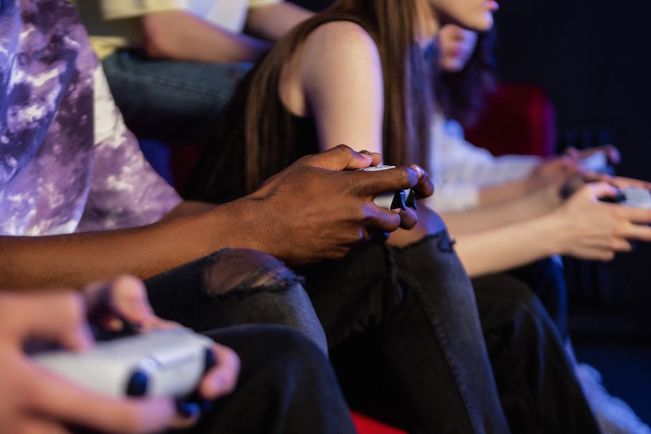 A collection of gaming controllers from PlayStation, Xbox, and Nintendo Switch laid out on a table, representing major gaming platforms.