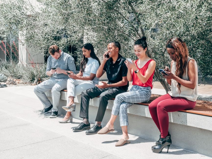 Close-up of diverse hands on smartphones and laptops, actively typing and submitting online reviews for various services, emphasizing the collective nature of user-generated content.