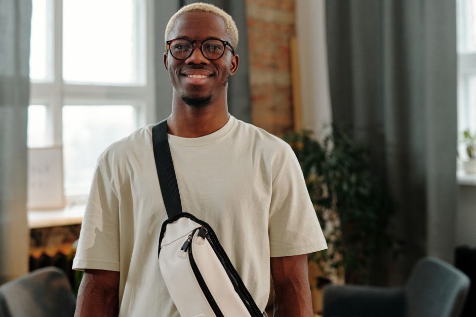 A diverse group of friends exploring a bustling market street, each wearing practical, secure crossbody bags or small backpacks, looking relaxed and engaged in conversation.