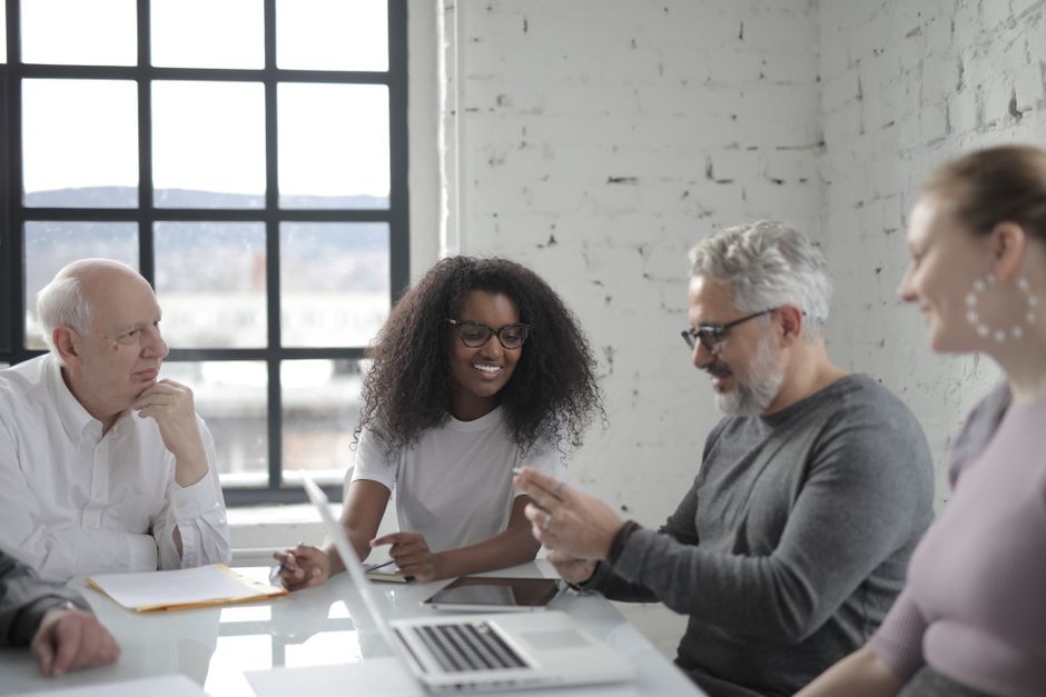 A diverse group of individuals from different continents (Europe, North America, South America) engaging in a video call, using a device that shows AI-powered translation for seamless cross-cultural communication.