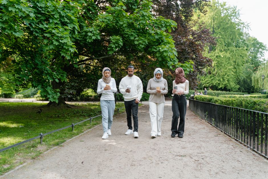 Friends of diverse ages walking together in a city park, showcasing social and accessible exercise.