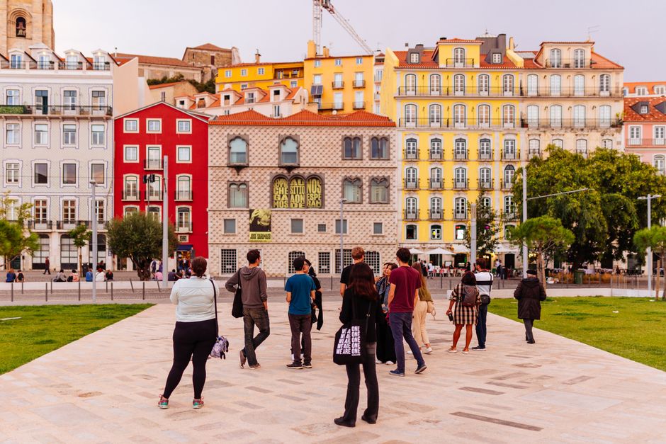 A group of friends or digital nomads walking through a historic European city square, looking up at detailed architecture, illustrating immersive travel experiences.