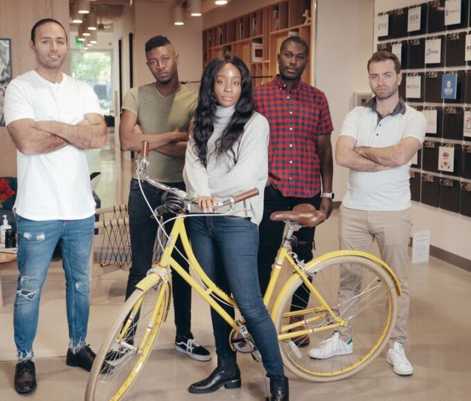 Diverse group of professionals in a modern office space, wearing smart casual work outfits suitable for hybrid jobs.