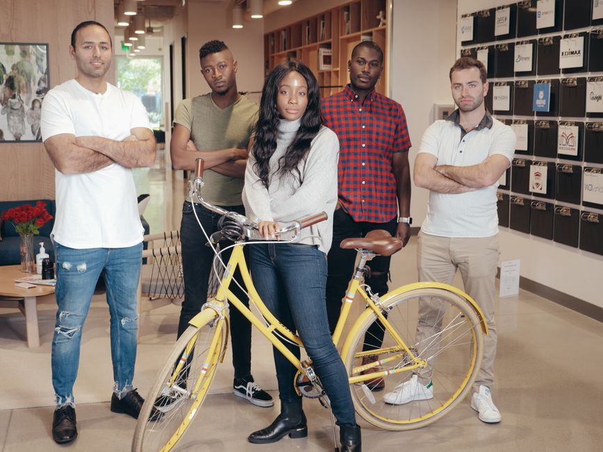 Diverse group of professionals in a modern office space, wearing smart casual work outfits suitable for hybrid jobs.