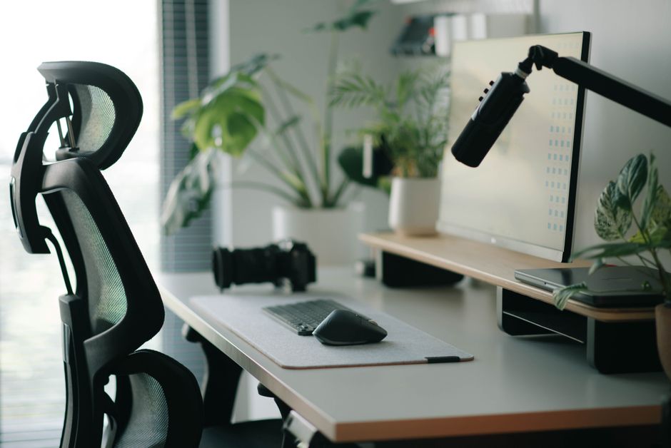 A properly adjusted ergonomic desk setup with a monitor at eye level, external keyboard, and mouse, demonstrating correct posture.