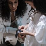 A family at a kitchen table, with a smart ring and a smartwatch laid out, comparing their features.