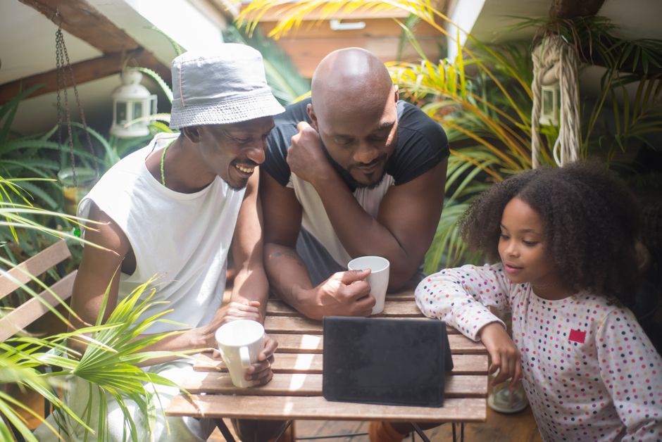 A family, including two parents and two children, sitting around a table having a serious but calm discussion.