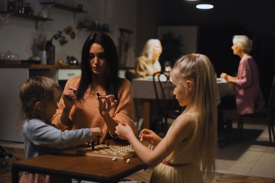 A family laughing and enjoying a board game together in a cozy living room, devices put away.