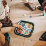 A multi-generational family happily engaged in a board game, with various generations visible around a brightly lit table.