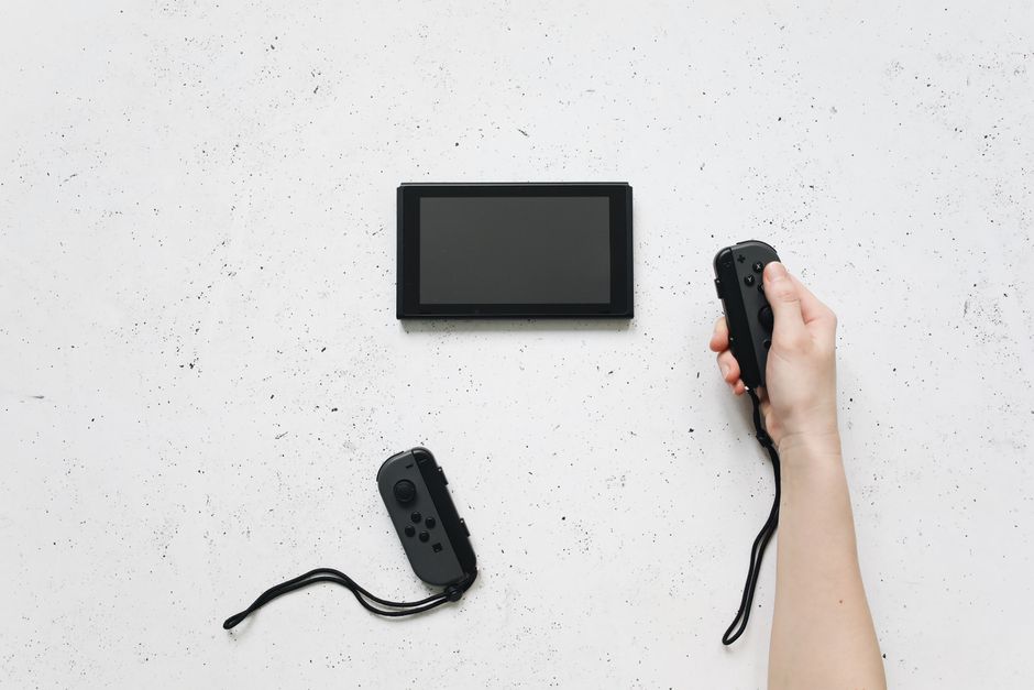 A diverse group of friends or family members enjoying a fitness game on a Nintendo Switch, using motion controllers in a living room.