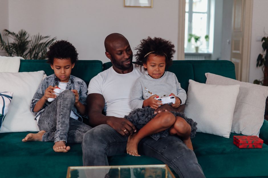 A family spread across various homes, each engaged in a video game on their respective devices, connected through an online multiplayer session.