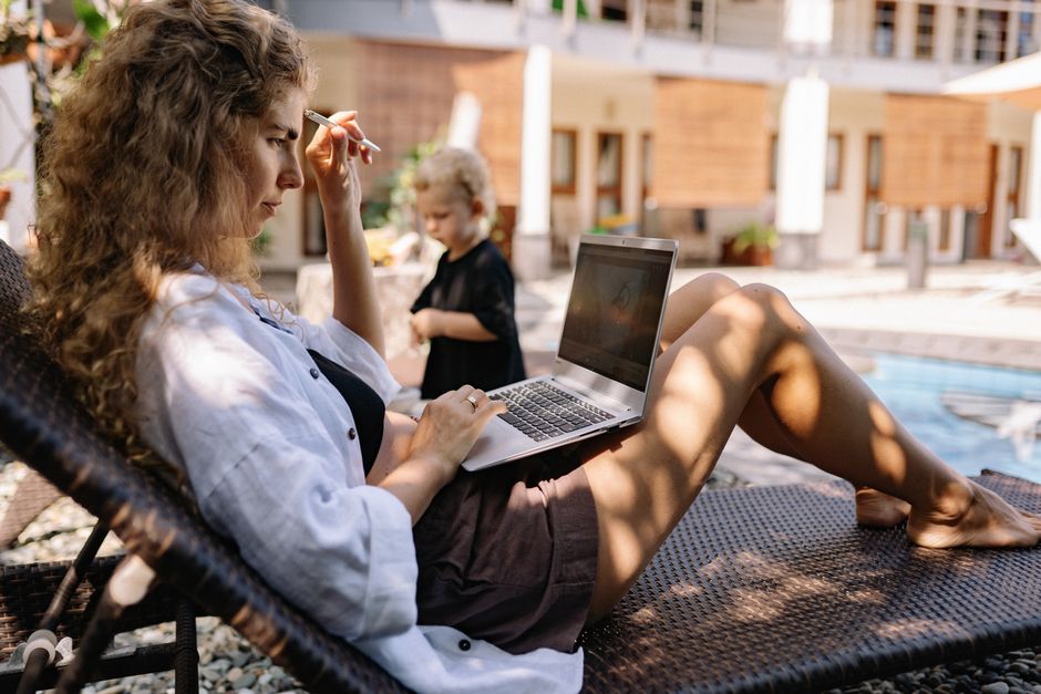 A family of four, including two young children, gathered around a laptop, intently looking at hotel review pages, illustrating the process of reading hotel reviews for vacation planning.