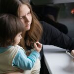 A family, including parents and children, gathered around a table with laptops, tablets, and phones, actively collaborating and using apps to organize their schedules and tasks.