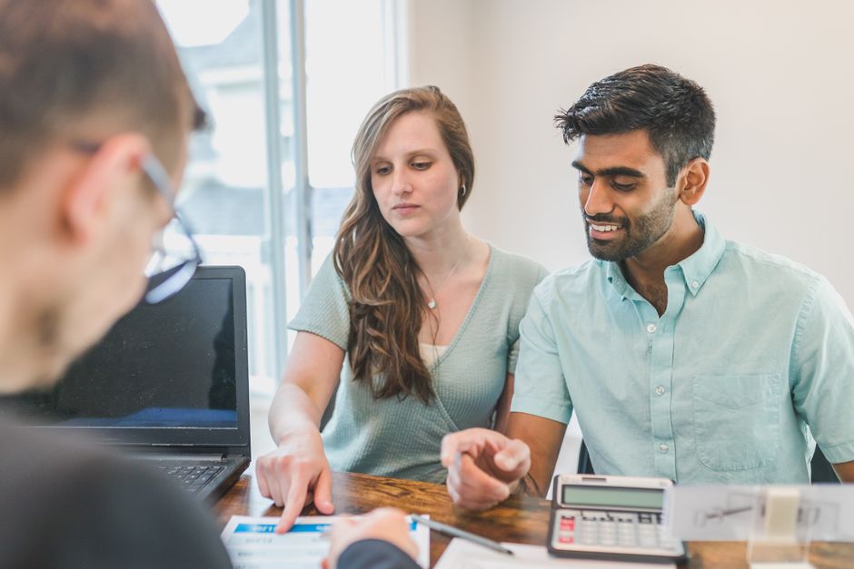 An expat couple consulting with a financial advisor on a laptop, discussing their international investment and tax strategies.
