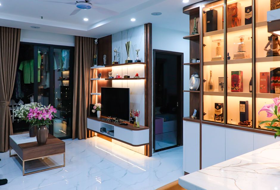 An organized and stylish rental apartment with a mix of modern and bohemian decor, showcasing a gallery wall, a comfortable armchair, and smart storage solutions.