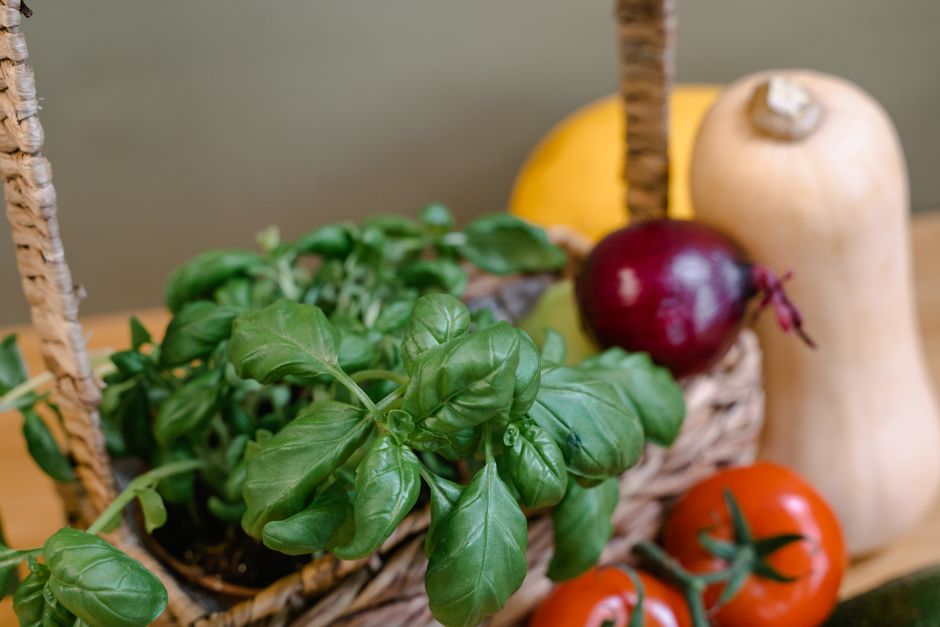 A close-up shot of various budget-friendly and healthy ingredients on a kitchen counter: dried lentils, canned tomatoes, eggs, whole grain pasta, and seasonal vegetables.