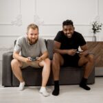 Friends using different gaming platforms (PlayStation, Xbox, PC) happily playing together on screens.