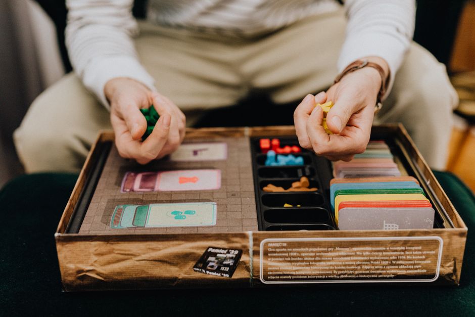 A group of friends laughing and playing a quick card game or light board game, highlighting social and brief gaming experiences.