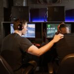 A person looking frustrated at their computer screen which shows a high ping notification during a game.
